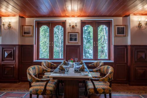 a dining room with a table and chairs at Cecil by Pearl Continental in Murree