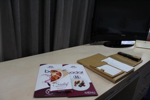 a desk with two books on a table with a computer at King Hotel Astana in Astana