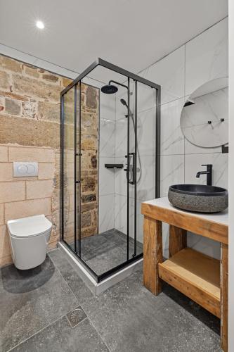 a bathroom with a glass shower with a toilet and a sink at Casa del Sol Suites in Rhodes Town