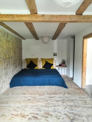 a bedroom with a blue bed with a stone wall at Apartment Sonnenschein in Bühl