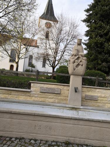 a statue in front of a building with a church at Apartment Sonnenschein in Bühl