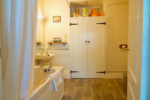 a bathroom with a sink and a tub and a toilet at Arosfa Harbourside Aberaeron in Aberaeron