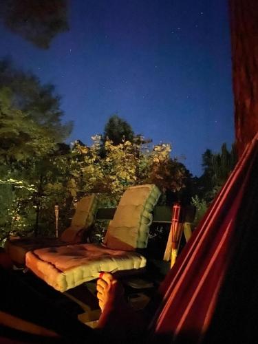 a person sitting in a hammock at night at Gästehaus Zur Walnuss Berlin in Blankenfelde