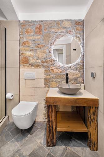a bathroom with a sink and a toilet and a mirror at Casa del Sol Suites in Rhodes Town