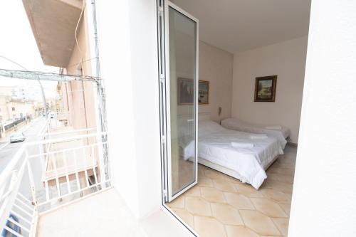 a bedroom with a bed and a glass door at Domus61 in Marsala