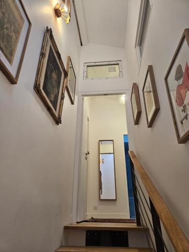 a hallway with pictures on the walls and a mirror at Villa Nomade - Bordeaux center 180m2, 4 rooms, Garden & Pool in Bordeaux