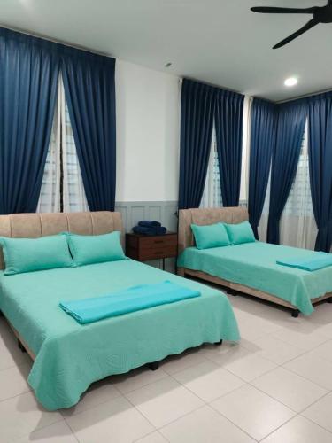 two beds in a room with blue curtains at Cik Yam Homestay Pool, Melaka l For Malay Only in Melaka