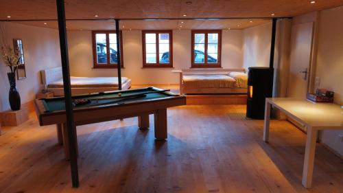 a room with a pool table in the middle of it at Sahlihuus Unterkunft in Köniz