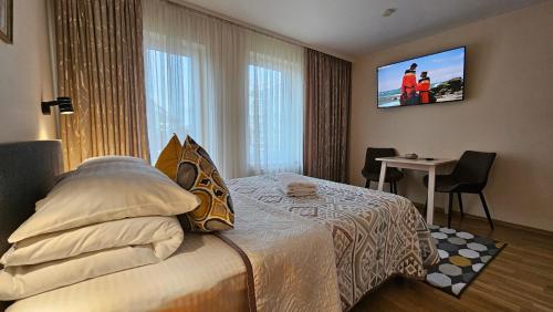 a hotel room with a bed and a tv on the wall at Nileja in Vilnius