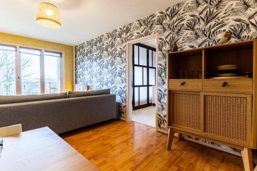 un salon avec un canapé et une table dans l'établissement Appartement parking Dijon proche centre Wilson, à Dijon