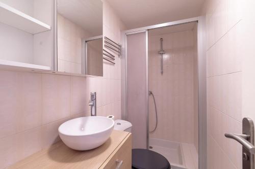 une salle de bain blanche avec un lavabo et une douche dans l'établissement Studio La Corniche - accès ocean et plage, à La Rochelle