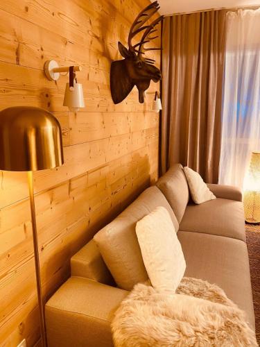 - un salon avec un canapé et une tête de cerf sur le mur dans l'établissement Bel appartement 8p pied des pistes Val Louron, à Val Louron