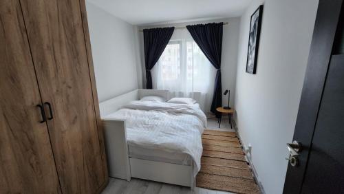 a small bedroom with a bed and a window at Retreat Apartment in Tîrgu Ocna