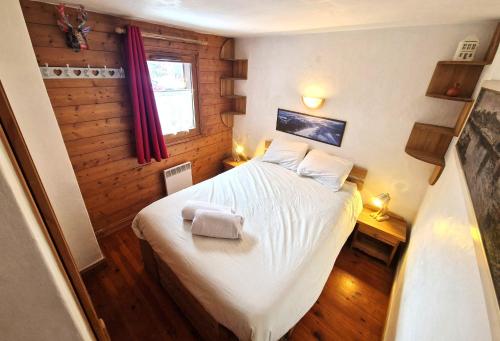 - une chambre avec un lit blanc dans une pièce dotée d'une fenêtre dans l'établissement La Ginabelle 2 - Vue MontBlanc, à Chamonix-Mont-Blanc