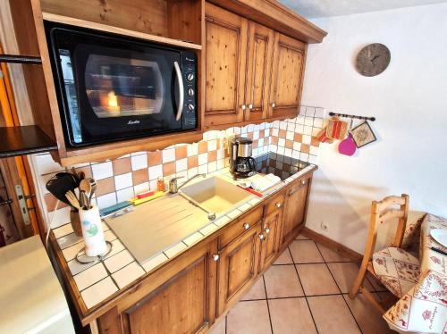 une cuisine avec un évier et un micro-ondes dans l'établissement La Ginabelle 2 - Vue MontBlanc, à Chamonix-Mont-Blanc