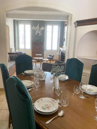 une table de salle à manger avec des assiettes et des verres dessus dans l'établissement Romantic apartment-Hyper centre, à Bagnères-de-Bigorre