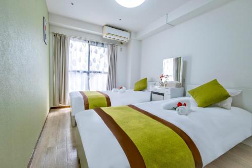 a hotel room with two beds and a window at marron home 大阪 in Osaka