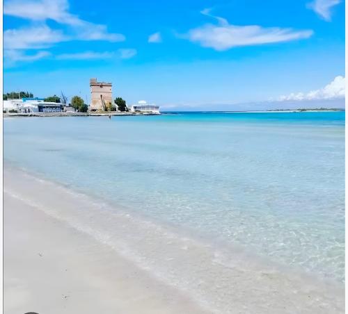 a view of a beach with a lighthouse in the distance at Stonehouse oasis in Sant'Isidoro
