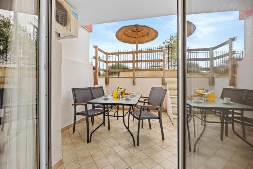 a patio with a table and chairs on a balcony at Residence Kamenjak in Premantura