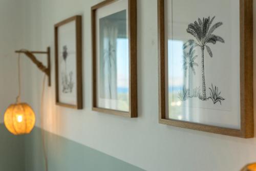 a row of framed pictures on a wall with a lamp at Villa Helissie in Vamos