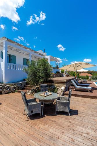 a patio with a table and two chairs and an umbrella at Villa Helissie in Vamos