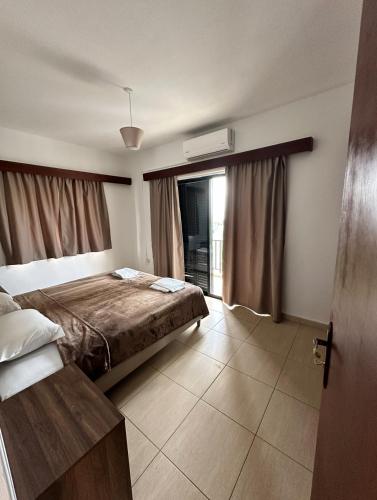 a hotel room with a bed and a window at New York Plaza Hotel Apartments in Paphos City