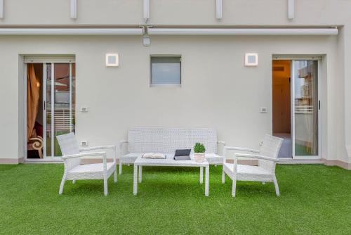 a patio with a table and chairs on grass at Hotel Polo in Rimini