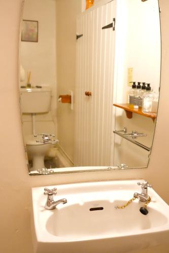 a bathroom sink with a mirror and a toilet at Arosfa Harbourside Aberaeron in Aberaeron