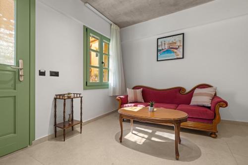 a living room with a red couch and a table at Casa del Sol Suites in Rhodes Town