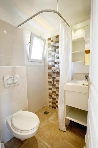 une salle de bain avec toilettes, lavabo et fenêtre dans l'établissement Résidence Les Castors, à Calvi