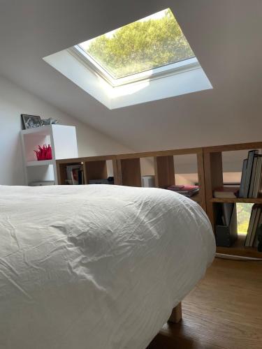 - une chambre avec un lit et une lucarne dans l'établissement Très beau duplex, 2 chambres, parking privé, plage à 5 minutes, à Sainte-Maxime