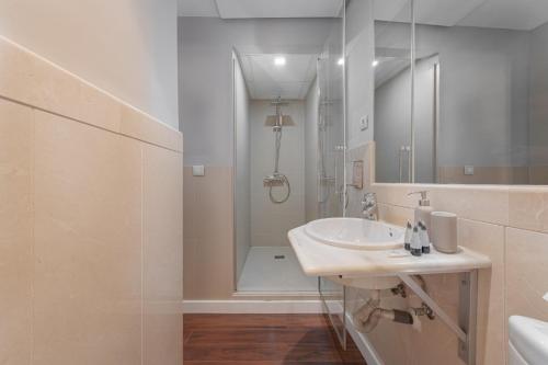 ein weißes Badezimmer mit Waschbecken und Dusche in der Unterkunft Cathedral Suites - Plaza del Obispo in Málaga