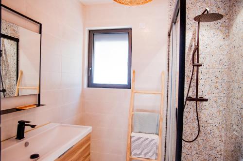 une salle de bain avec un lavabo et une douche dans l'établissement NoMad Home, avec 1 parking privé à 2 pas de La Cité Médiévale, à Carcassonne