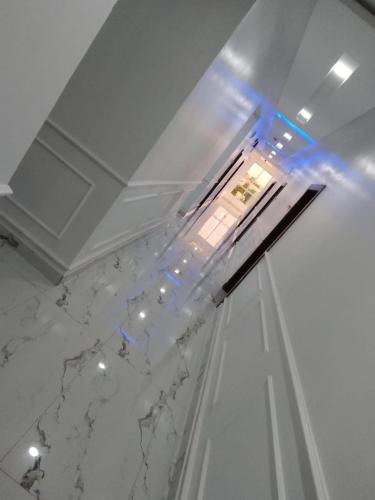 a room with a white marble ceiling with blue lights at De-Lites Hotel in Asaba