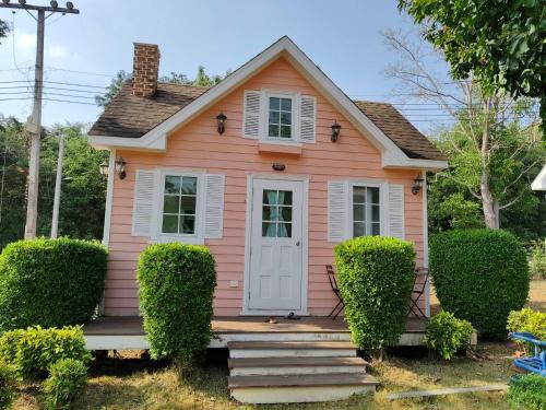 a pink tiny house with a white door at The Open Hills in Chongsadao