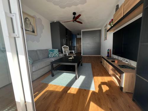 a living room with a couch and a tv at Calypso Holidays in Sitio de Calahonda