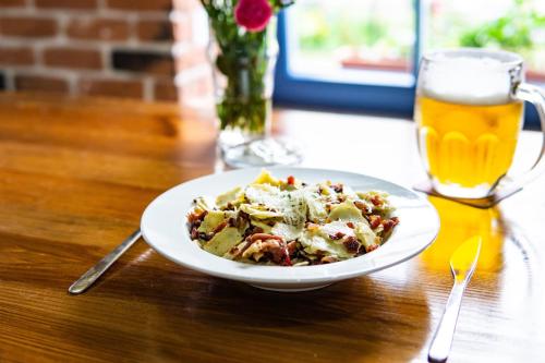 a plate of food on a table with a glass of beer at Apartments Eibenthal in Eibenthal