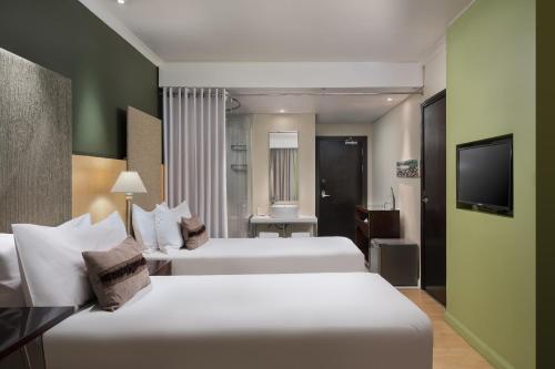 a hotel room with two beds and a television at Protea Hotel by Marriott Bloemfontein Willow Lake in Bloemfontein