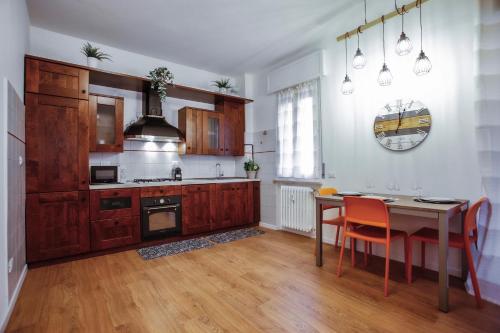 a kitchen with wooden cabinets and a table with chairs at Bella Ciao BGY Airport in Zanica