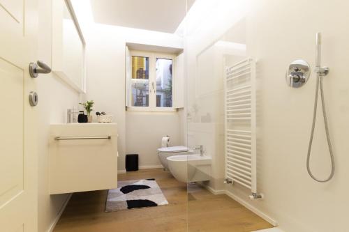 a white bathroom with a toilet and a shower at Luxury flat by the lake in Morcote