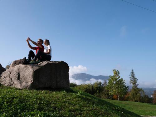 two people sitting on a rock on a hill at Innesti Rooms&Apartments - Le camere in Pergine Valsugana