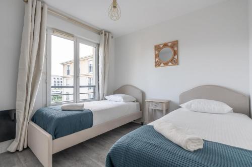 une chambre avec deux lits et une fenêtre dans l'établissement Disney à Paris - Fontaine Rouge, à Chessy