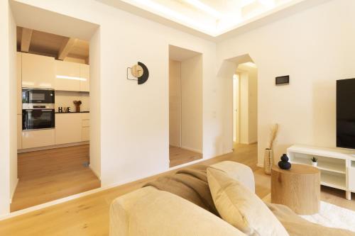a living room with a couch and a tv at Luxury flat by the lake in Morcote