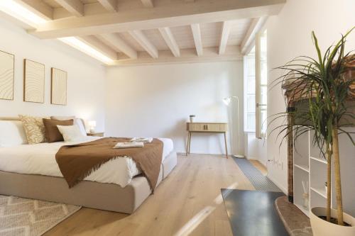 a white bedroom with a bed and a table at Luxury flat by the lake in Morcote