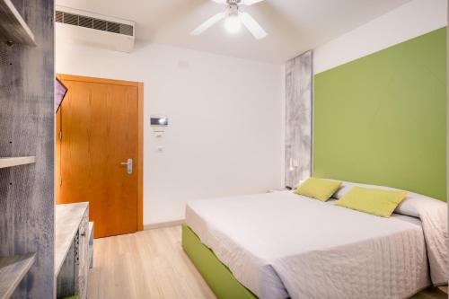 a bedroom with a bed with a green wall at All'Orologio - Boutique Hotel in Caorle