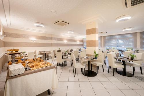 a restaurant with tables and chairs and food on display at All'Orologio - Boutique Hotel in Caorle