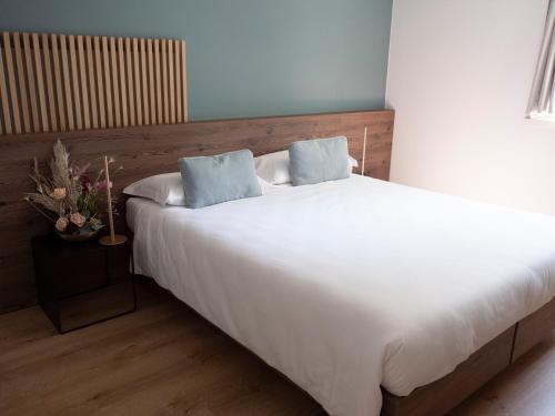 a bedroom with a large white bed with two pillows at Innesti Rooms&Apartments - Le camere in Pergine Valsugana