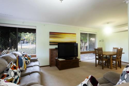 a living room with a couch and a flat screen tv at Well equipped 3BR Home with Backyard and Patio in Perth