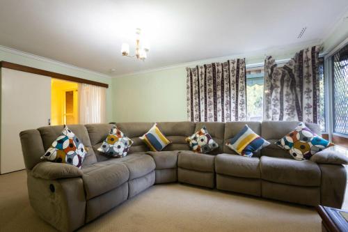 a living room with a couch with pillows on it at Well equipped 3BR Home with Backyard and Patio in Perth
