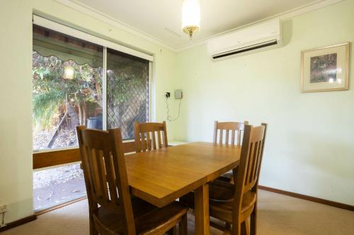 a dining room with a wooden table and chairs at Well equipped 3BR Home with Backyard and Patio in Perth